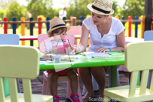 Image of mom and little daughter drawing a colorful pictures