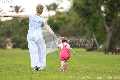 Image of mother and little daughter playing at backyard