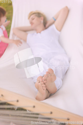 Image of mother and a little daughter relaxing in a hammock