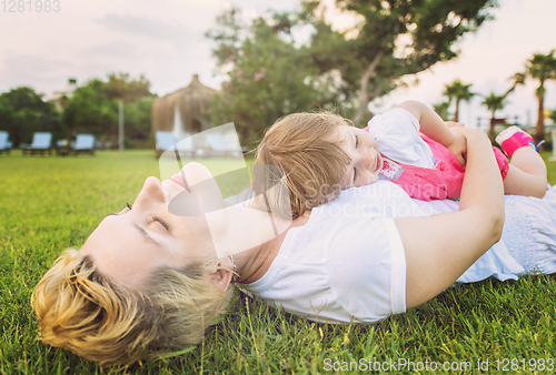 Image of mother and little daughter playing at backyard