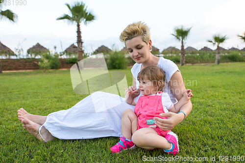 Image of mother and little daughter playing at backyard