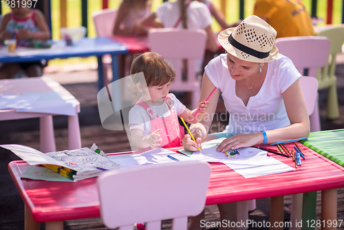 Image of mom and little daughter drawing a colorful pictures