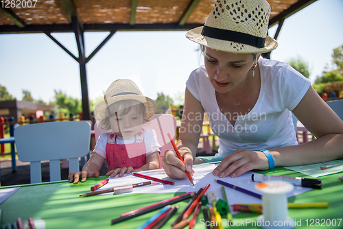 Image of mom and little daughter drawing a colorful pictures