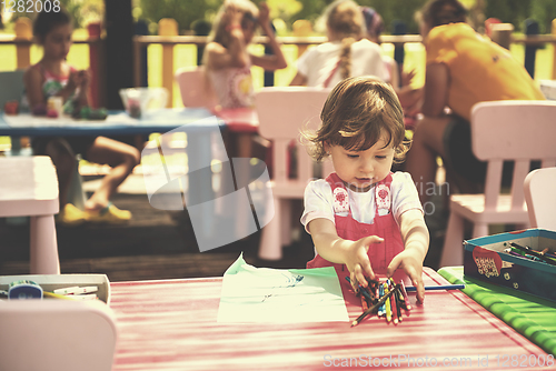 Image of little girl drawing a colorful pictures