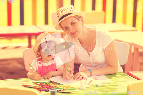 Image of mom and little daughter drawing a colorful pictures