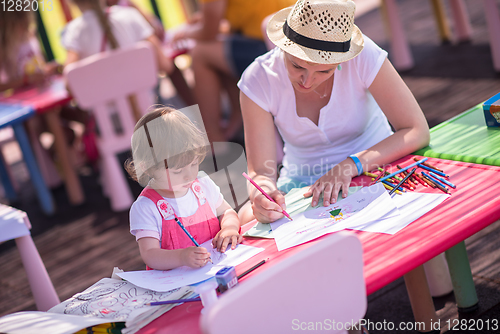 Image of mom and little daughter drawing a colorful pictures