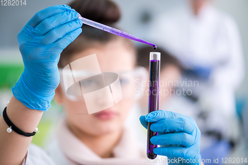 Image of female student with protective glasses making chemistry experime