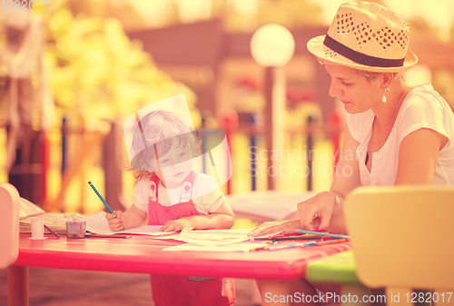 Image of mom and little daughter drawing a colorful pictures