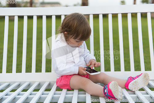 Image of little girl playing with mobile phone