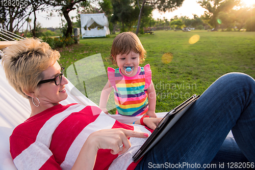 Image of mom and a little daughter relaxing in a hammock