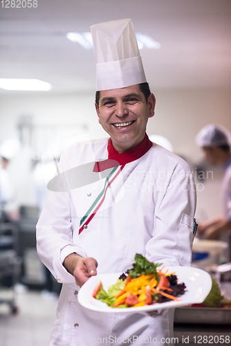 Image of Chef showing a plate of tasty meal