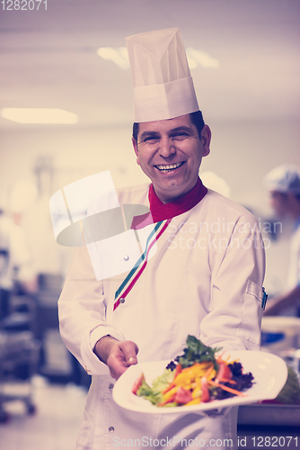 Image of Chef showing a plate of tasty meal