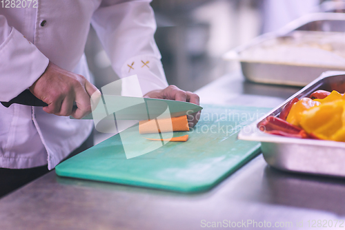 Image of Chef hands cutting fresh and delicious vegetables