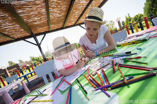 Image of mom and little daughter drawing a colorful pictures