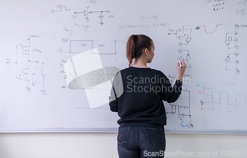Image of female student writing on board in classroom
