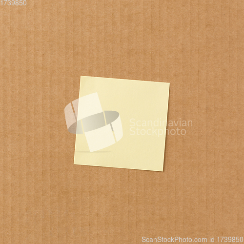 Image of Yellow sticky paper note on cardboard