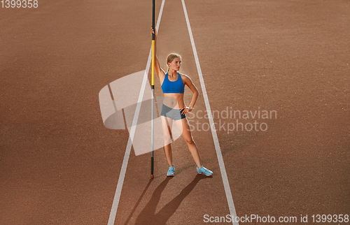 Image of Female high jumper training at the stadium in sunny day