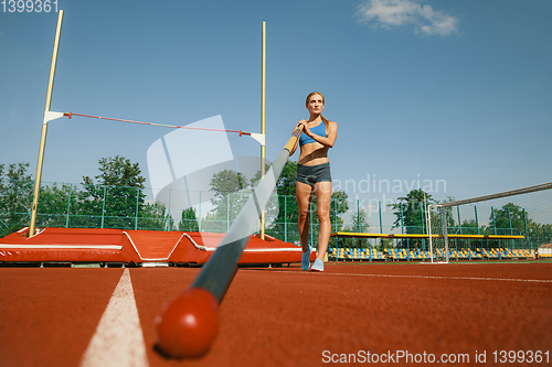 Image of Female high jumper training at the stadium in sunny day