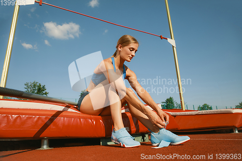 Image of Female high jumper training at the stadium in sunny day