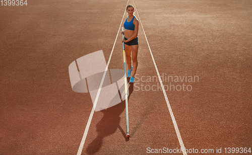 Image of Female high jumper training at the stadium in sunny day