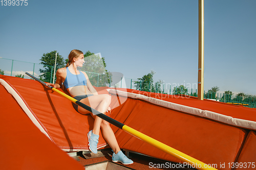 Image of Female high jumper training at the stadium in sunny day