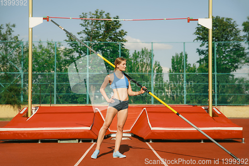 Image of Female high jumper training at the stadium in sunny day