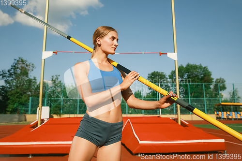 Image of Female high jumper training at the stadium in sunny day