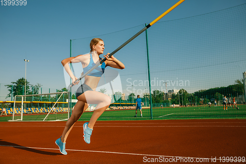 Image of Female high jumper training at the stadium in sunny day