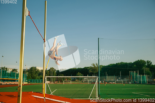 Image of Female high jumper training at the stadium in sunny day