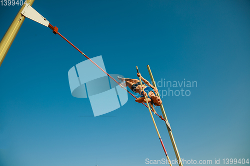 Image of Female high jumper training at the stadium in sunny day