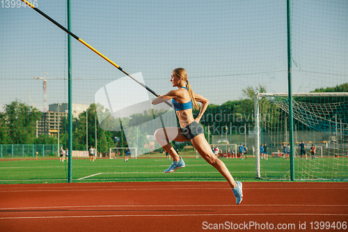 Image of Female high jumper training at the stadium in sunny day