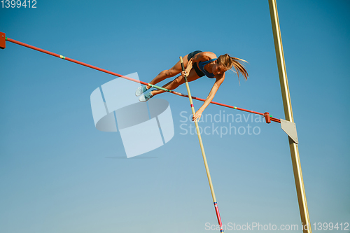 Image of Female high jumper training at the stadium in sunny day