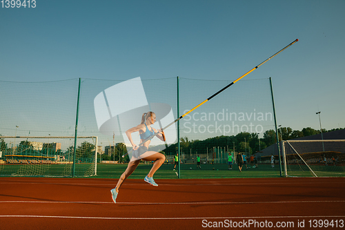 Image of Female high jumper training at the stadium in sunny day