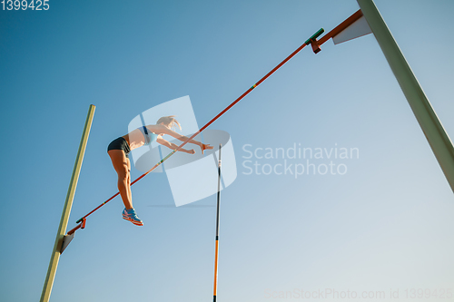 Image of Female high jumper training at the stadium in sunny day