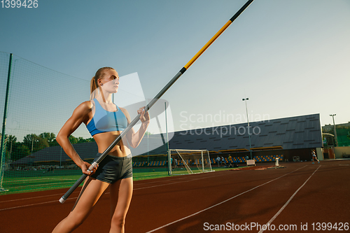 Image of Female high jumper training at the stadium in sunny day