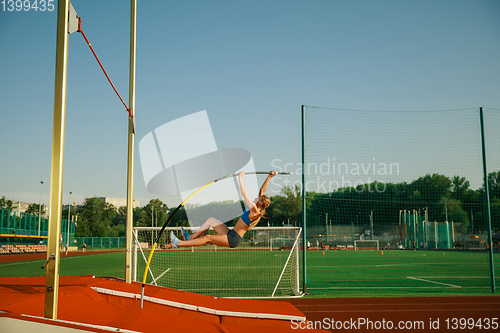 Image of Female high jumper training at the stadium in sunny day