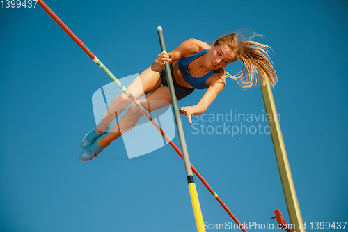 Image of Female high jumper training at the stadium in sunny day