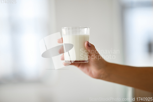 Image of close up of female hand holding glass of milk