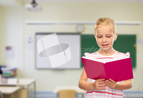 Image of smiling little girl reading book