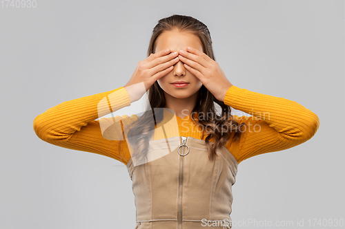 Image of teenage girl closing her eyes by hands