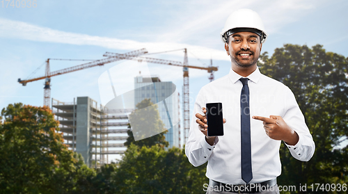 Image of architect showing smartphone at construction site