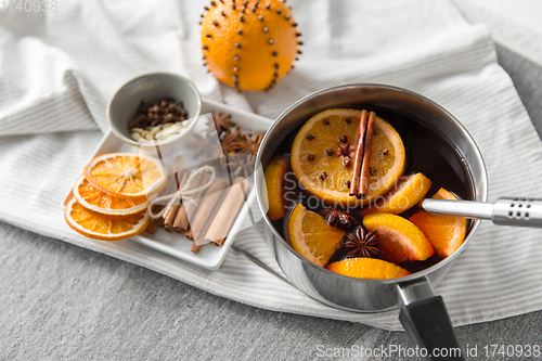 Image of pot with hot mulled wine, orange slices and spices