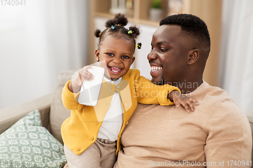 Image of father and baby daugter with smartphone at home