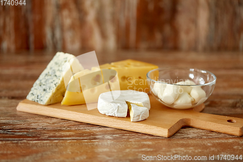 Image of different kinds of cheese on wooden cutting board