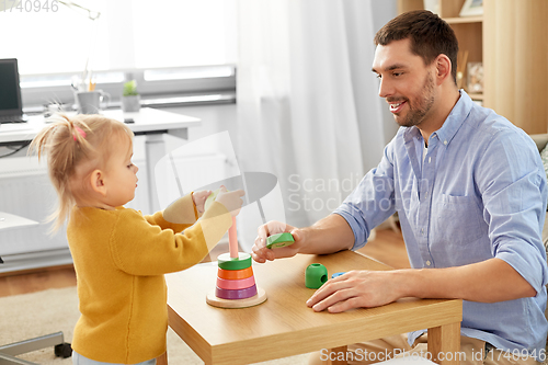 Image of father playing with little baby daughter at home