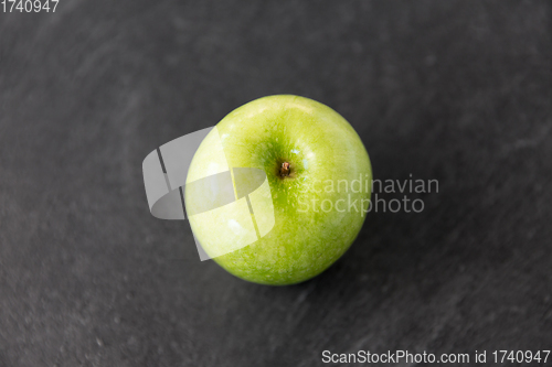 Image of ripe green apple on slate stone background