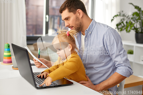 Image of working father with baby daughter at home office