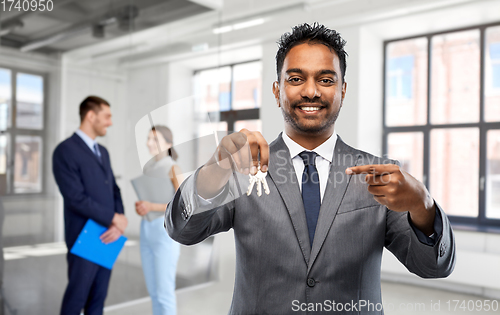 Image of indian man realtor with keys at empty office room