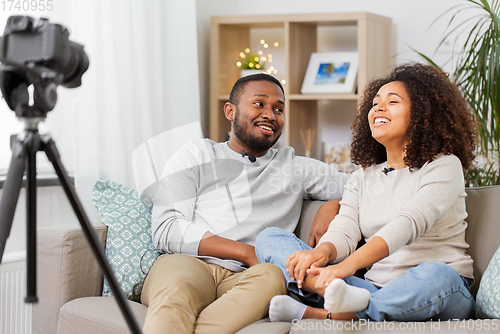 Image of couple of video bloggers with camera at home