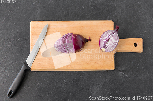 Image of red onion and kitchen knife on cutting board